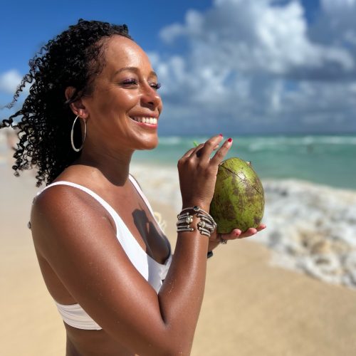 women sipping a coconut at the beach